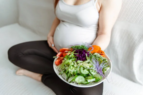 怀孕最后几个月的准妈妈拿着一盘蔬菜沙拉 — 图库照片