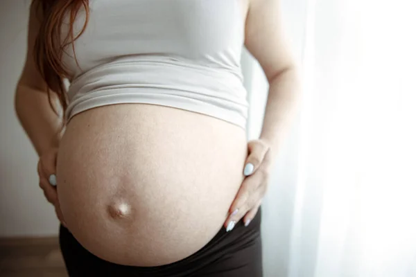 在怀孕的最后几个月里对孕妇的裸体腹部进行了密切的观察 — 图库照片