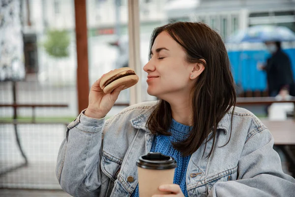 밖에서 햄버거와 커피를 즐기고 여자의 — 스톡 사진