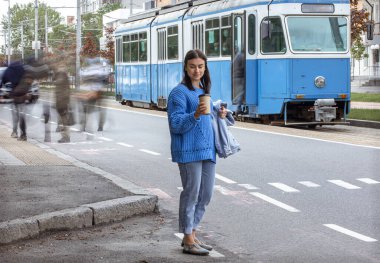 Şehirde yürüyüşe çıkmak için kahveli şık bir genç kız..