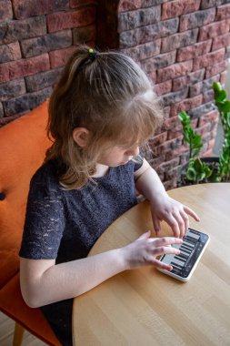 Küçük bir kız telefonundaki bir piyanonun yardımıyla notaları eğlenceli bir şekilde öğreniyor..