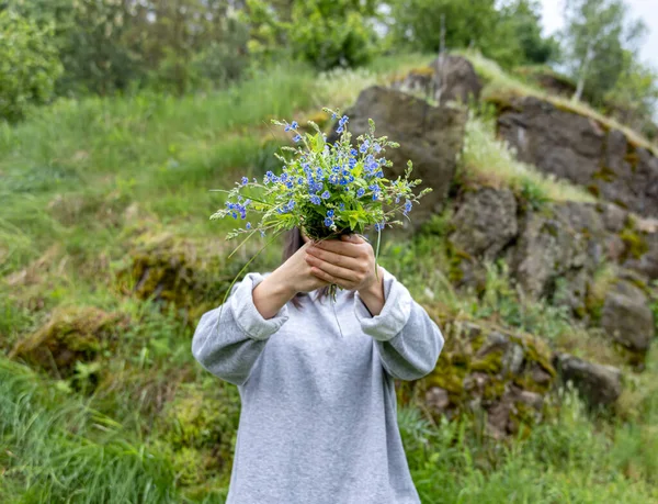 Dívka Skrývá Svou Tvář Kyticí Čerstvých Květin Shromážděných Lese — Stock fotografie