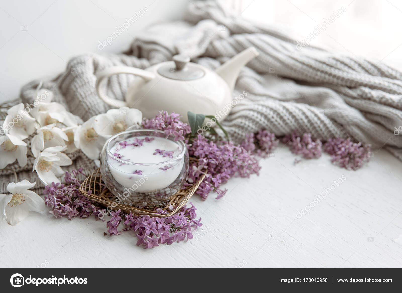 A cozy composition with candles, dried flowers in a vase and a knitted  element. Stock Photo by puhimec