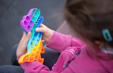 Popüler rengarenk anti-stres dokunmatik oyuncak itme onu bir çocuğun ellerine koy.
