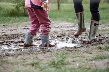 Lastik çizmeli çocuklar ormanda bataklıkta yürüyorlar..