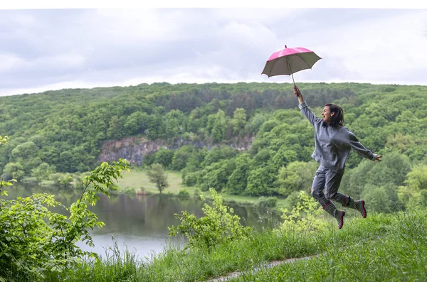 Ein Mädchen Unter Einem Regenschirm Springt Bei Regnerischem Wetter Der — Stockfoto