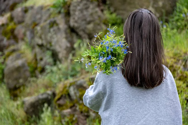 Dziewczyna Niesie Bukiet Kwiatów Zebranych Wiosennym Lesie Widok Tyłu — Zdjęcie stockowe