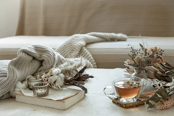 Bir bardak çay, örgü elementler ve odanın içinde kurumuş çiçekler..