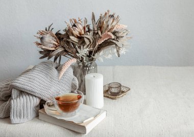 Bir fincan çay, örgü ögesi ve kitap kopyalama aletiyle İskandinav tarzında bir hayat..