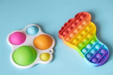 Moda çocuk oyuncakları anti-stresi patlat ve mavi arka planda basit bir gamze yap..