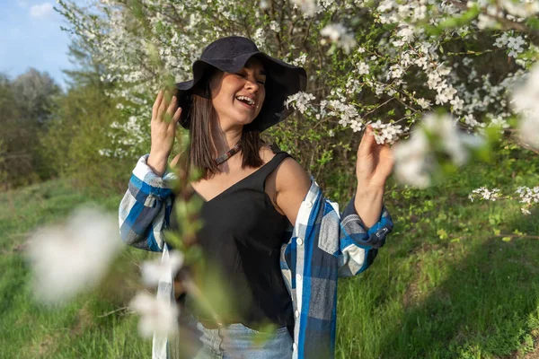 Attraktive Fröhliche Mädchen Mit Hut Zwischen Den Blühenden Bäumen Frühling — Stockfoto