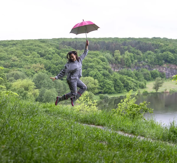 Ein Mädchen Unter Einem Regenschirm Springt Bei Regnerischem Wetter Der — Stockfoto