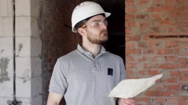 İnşaatçı bir inşaat alanında çizim yapıyor..