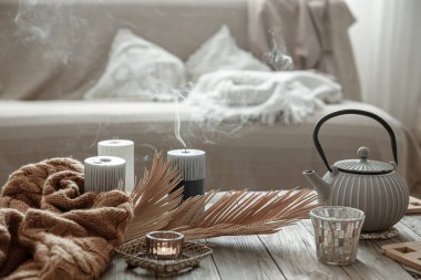 Çay ve mumlarla dolu çaydanlık odanın içindeki masanın üstünde..