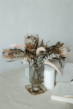 Bir buket çiçek, örgü ve dekoratif detaylarla İskandinav tarzı bir hayat..