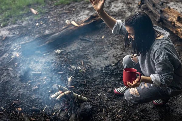 Ein Mädchen Mit Einer Tasse Der Hand Heizt Das Feuer — Stockfoto