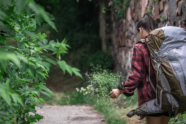 Attraktive Touristin Mit Großem Reiserucksack Und Einem Strauß Wildblumen — Stockfoto