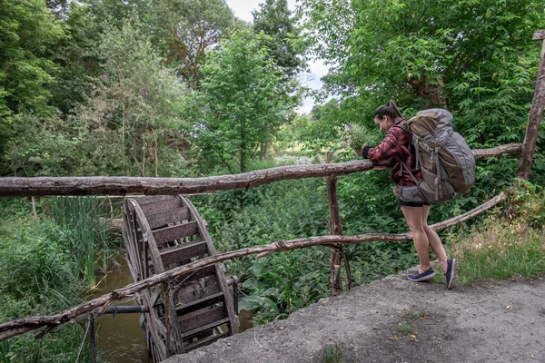 Attraktive Touristin Mit Großem Reiserucksack Und Einem Strauß Wildblumen — Stockfoto