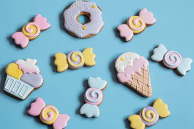 Düz, parlak zencefilli kurabiyeler, mavi arka planda tatlı şeklinde..