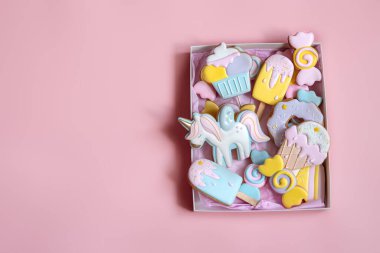 Pembe arka plan fotokopi alanındaki farklı şekillerde renkli zencefilli kurabiyeler..