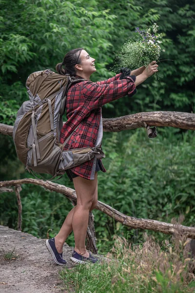 Attraktive Touristin Mit Großem Reiserucksack Und Einem Strauß Wildblumen — Stockfoto