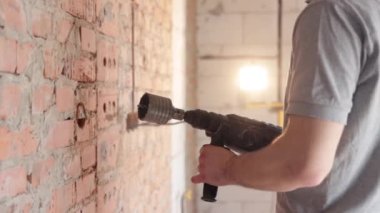 İnşaat alanında elinde matkapla çalışan bir adam..