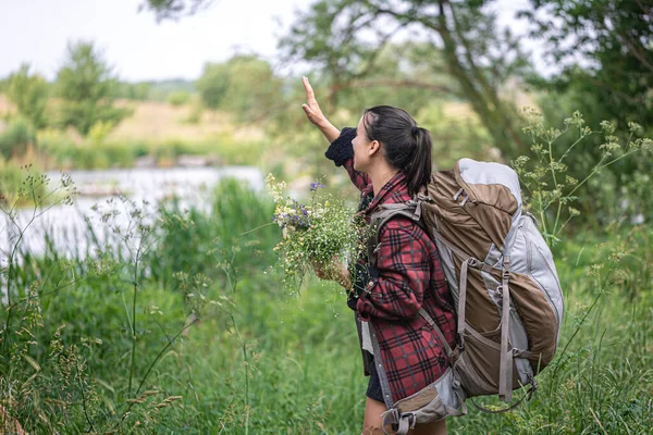 Attraktives Mädchen Mit Großem Reiserucksack Und Einem Strauß Wildblumen — Stockfoto