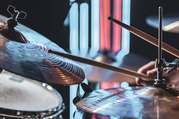 Close-up of drum cymbals as the drummer plays with beautiful lighting on a blurred background.