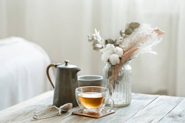 Bir bardak çay, mumlar ve bulanık arka plan fotokopi alanındaki örülmüş elementlerle dolu rahat bir hayat..