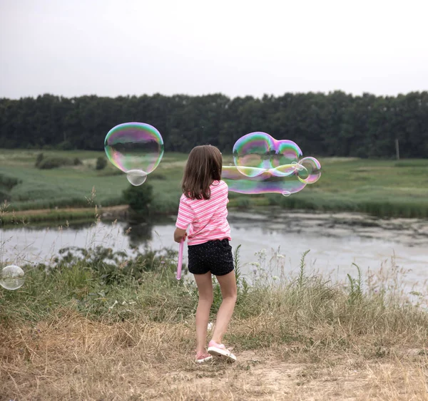 Маленькая Девочка Запускает Огромные Мыльные Пузыри Заднем Плане Красивая Природа — стоковое фото