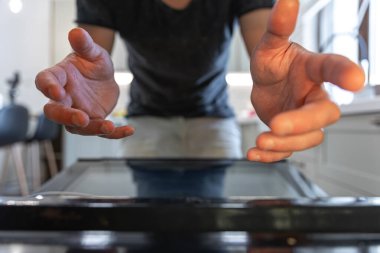 Erkek ellerinin yakın çekimi fırından bir şey çıkarır..