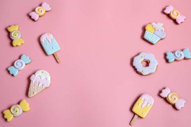 Pembe arkaplan fotokopisi üzerinde parlak zencefilli kurabiye kurabiyeleriyle düz kompozisyon.