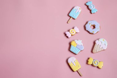 Pembe arkaplan fotokopisi üzerinde parlak zencefilli kurabiye kurabiyeleriyle düz kompozisyon.