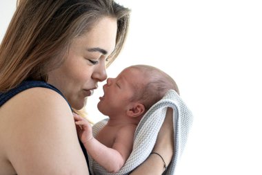 Anne ve yeni doğmuş bebeğinin portresi, beyaz arka planda yüz yüze..