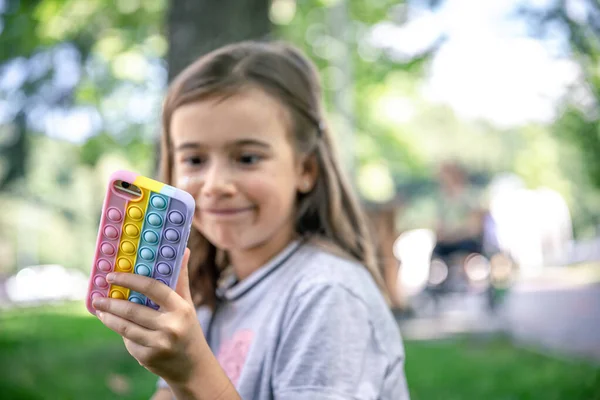 Ein Kleines Mädchen Hält Der Hand Ein Handy Einem Etui — Stockfoto