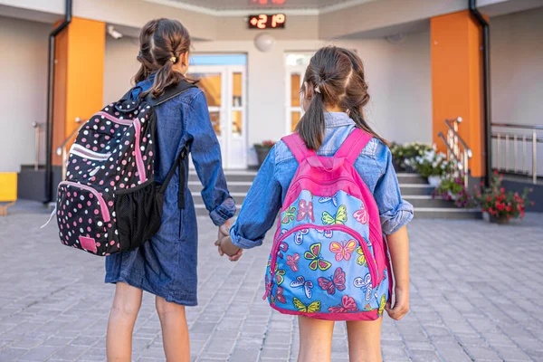 Küçük Kızlar Ilkokul Öğrencileri Sırt Çantalarıyla Okula Gider Ele Tutuşurlar — Stok fotoğraf