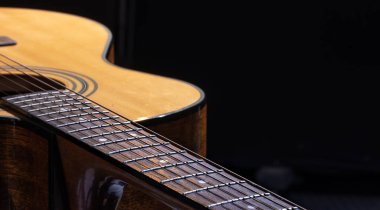 Akustik gitar, siyah arka planda güzel bir ahşap..