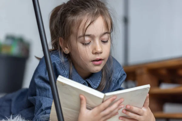 Портрет Маленькой Девочки Читающей Книгу Лежащую Полу Комнате — стоковое фото