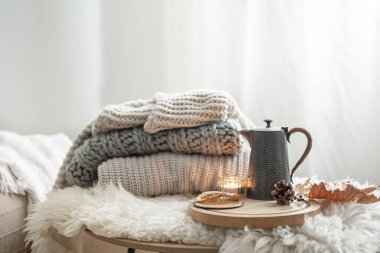 Arka plandaki bulanık fotokopi alanında örülmüş süveterler ve çaydanlık çaydanlıkla ev hayatı.