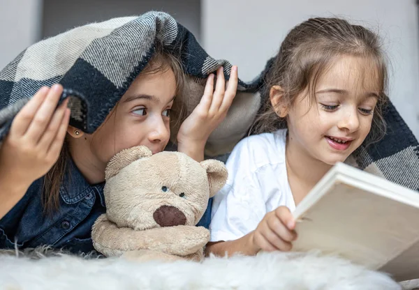 Kleine Schwestern Lesen Ein Buch Mit Einem Teddybär Der Zimmer — Stockfoto
