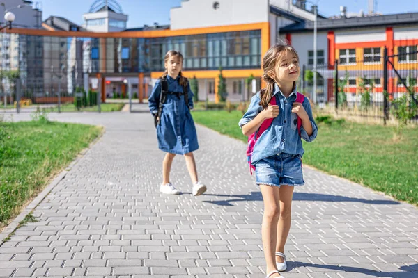 小学的学生 在室外建筑附近背着背包的女孩 开始上课 秋天的第一天 — 图库照片