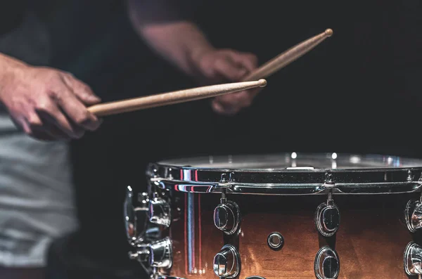 A man plays a snare drum with sticks, a drummer plays a percussion instrument, close up.