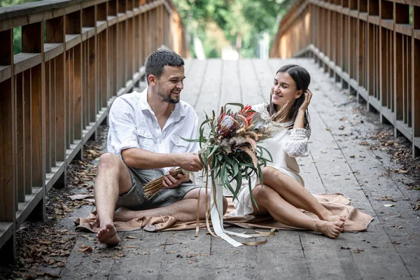 소녀와 남자가 다리에 의사소통을 즐기고 자연의 데이트를 즐기고 이야기를 나눕니다 — 스톡 사진