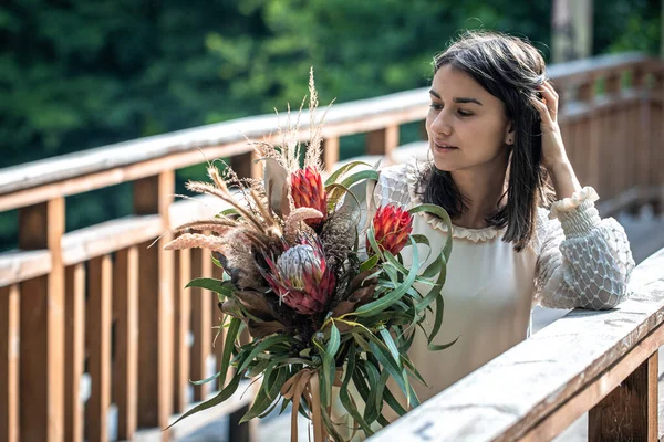 Attraktiv Ung Kvinna Träbro Står Med Bukett Exotiska Blommor — Stockfoto