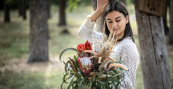 Ung Brunett Kvinna Vit Klänning Med Bukett Blommor Skogen Suddig — Stockfoto