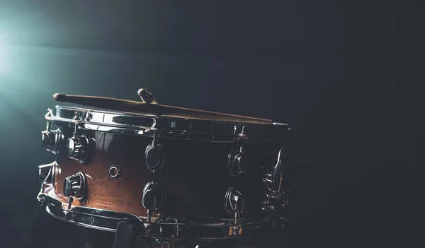 Close-up of a snare drum, percussion instrument on a dark background with beautiful lighting, copy space.