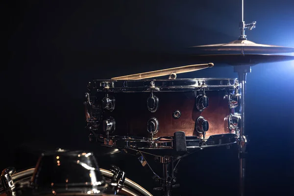 Snare drum, percussion instrument on a dark background with stage lighting.