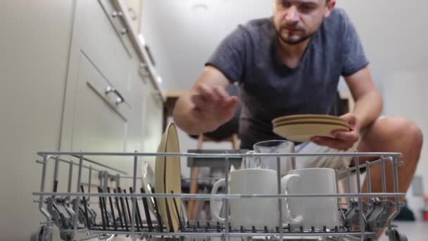 一个男人把脏盘子和其他盘子放在洗碗机里 — 图库视频影像