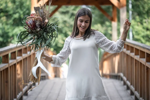 Vacker Flicka Vit Klänning Med Bukett Exotiska Blommor Träbro — Stockfoto