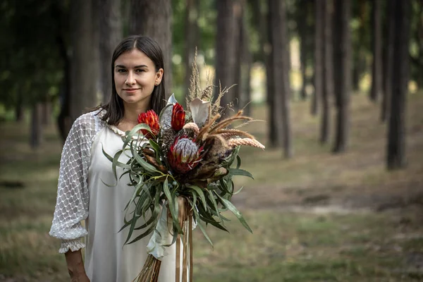 Ung Brunett Kvinna Vit Klänning Med Bukett Blommor Skogen Suddig — Stockfoto